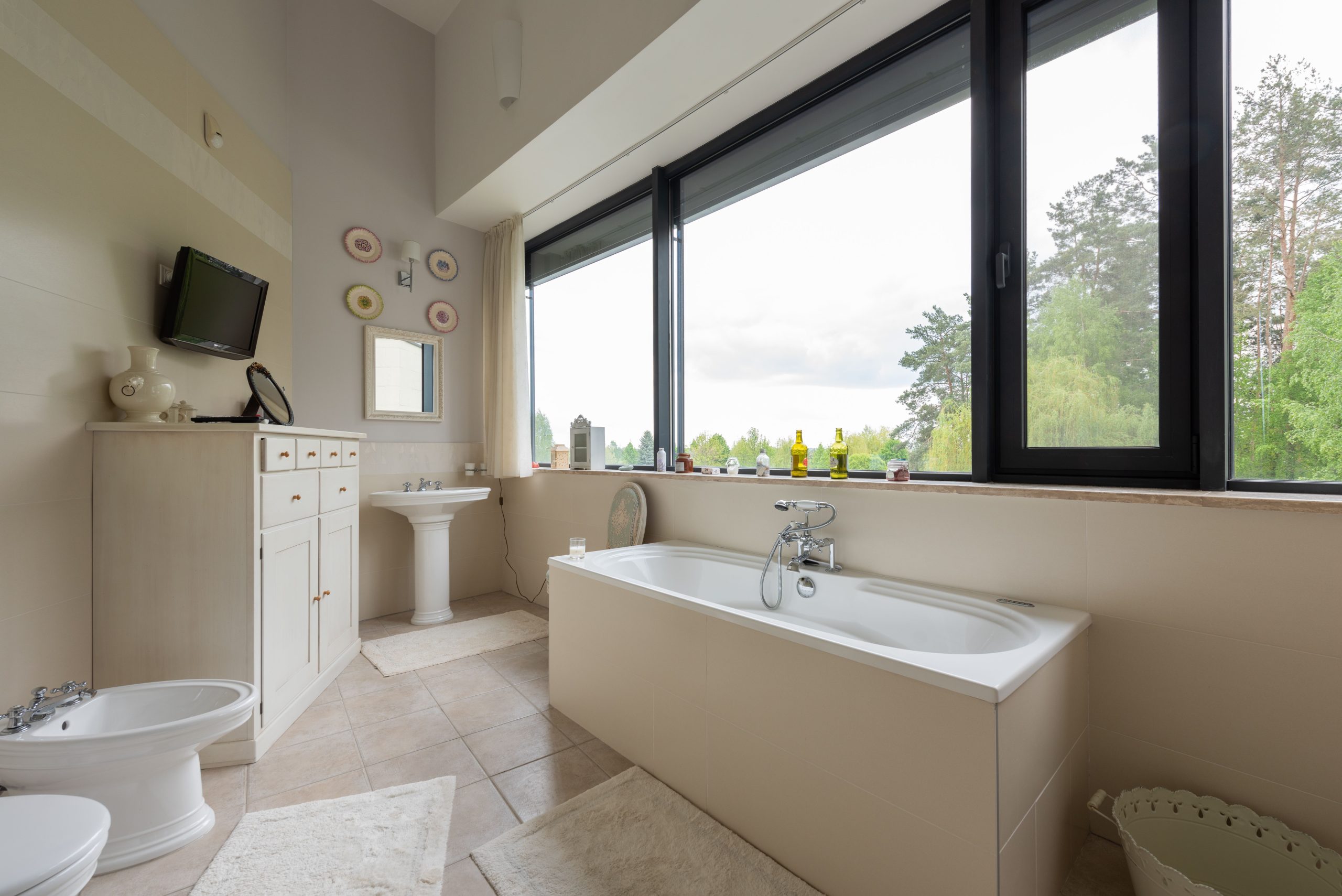 Salle de bain spacieuse avec baignoire près grande fenêtre