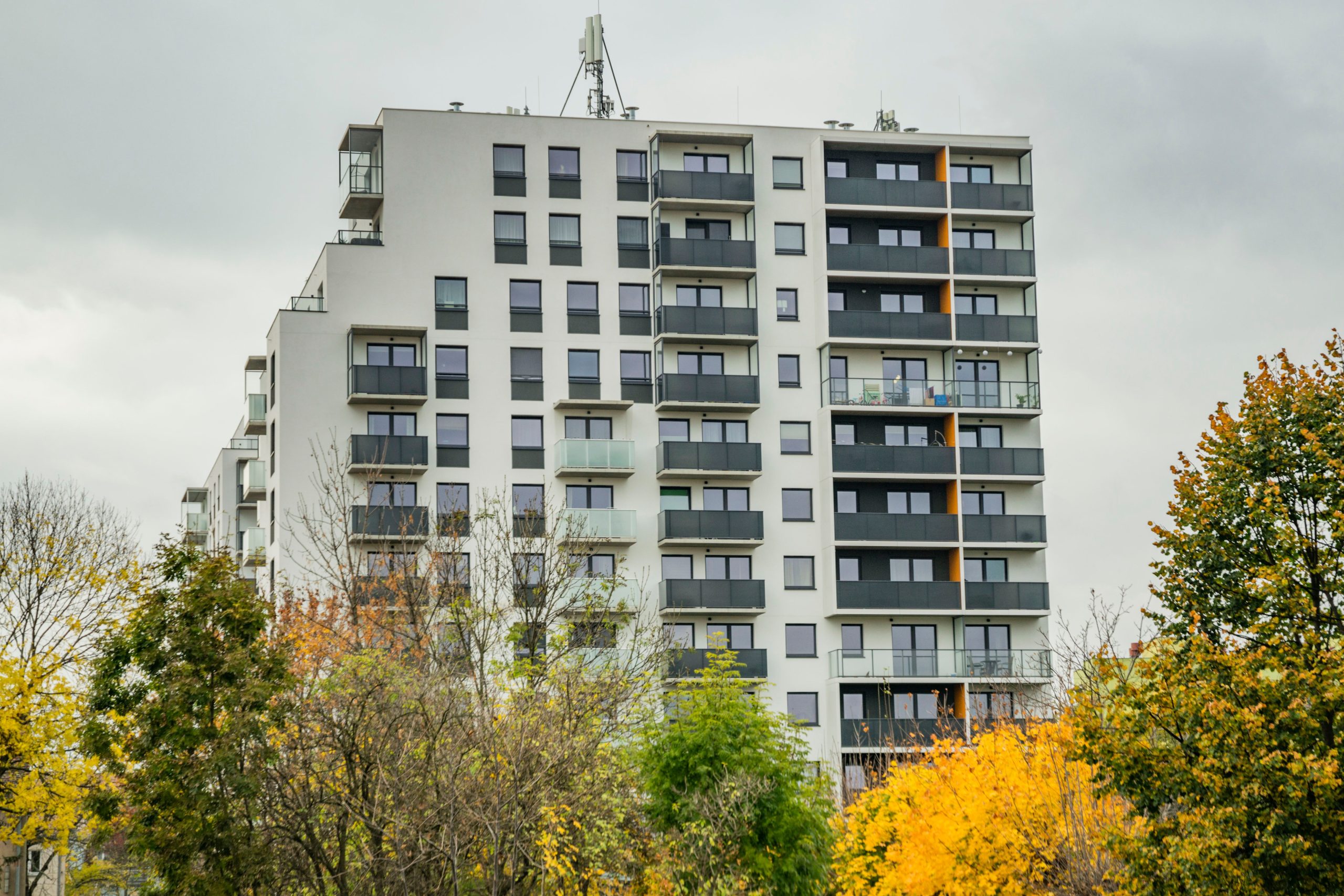 Tour résidence automne arbres colores ciel nuageux