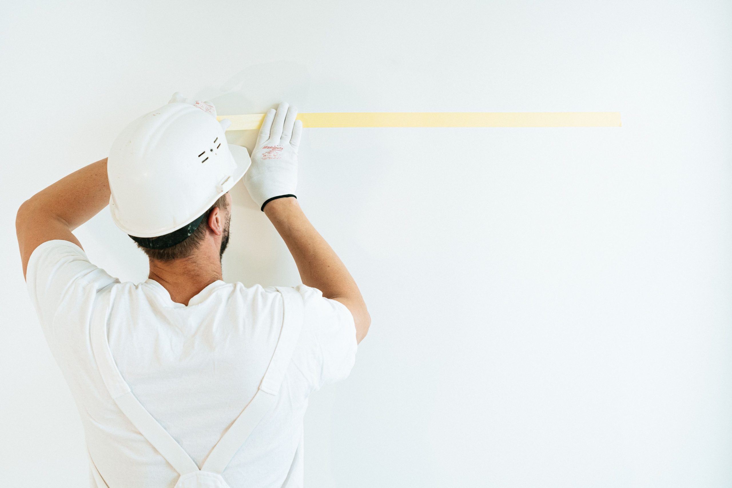 Ouvrier pose scotch peinture avant peinture