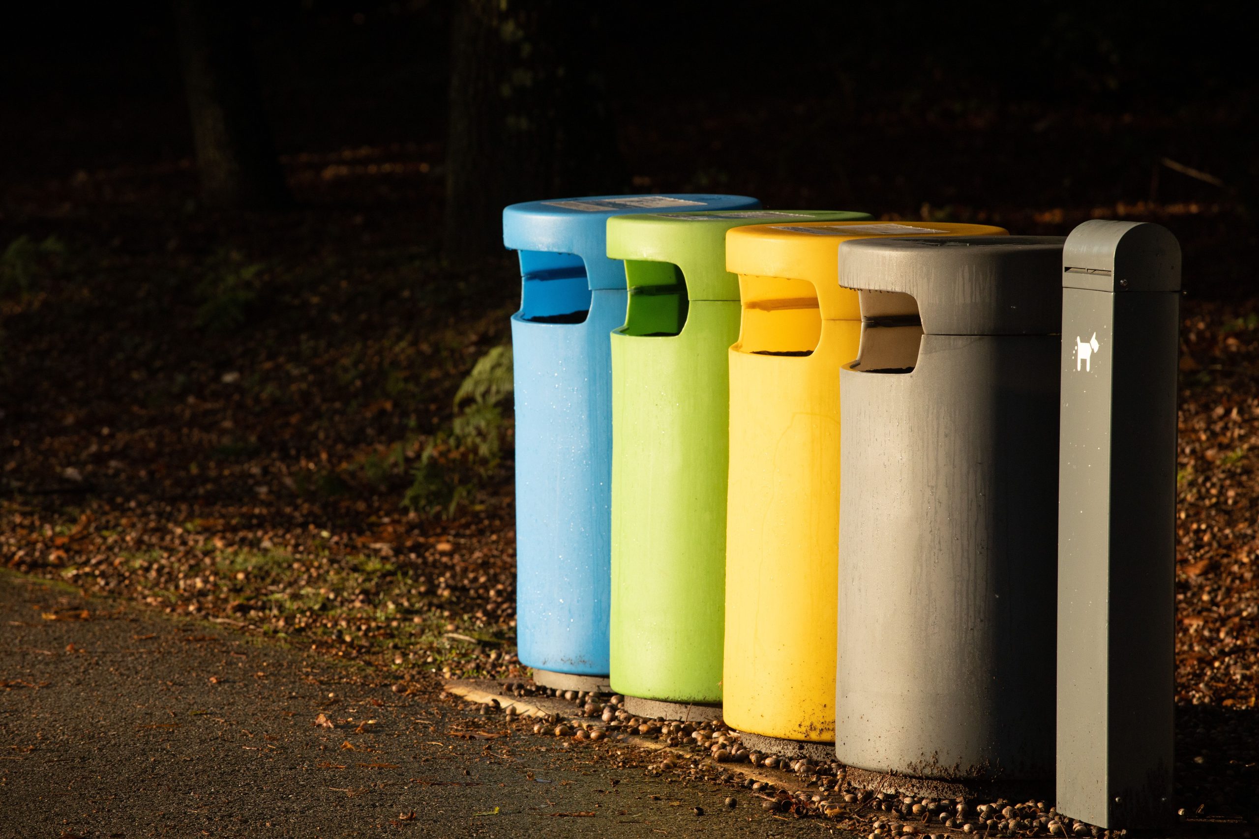 Rangée de bacs recyclage colorés sur trottoir