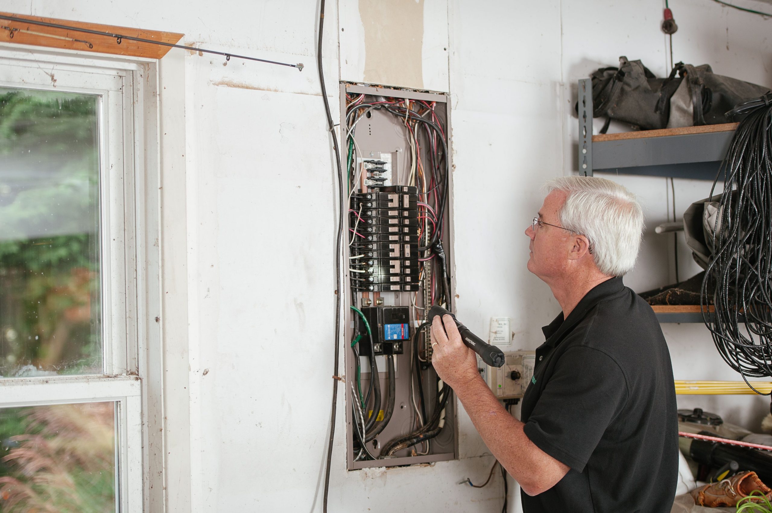 Électricien examinant un tableau électrique résidentiel