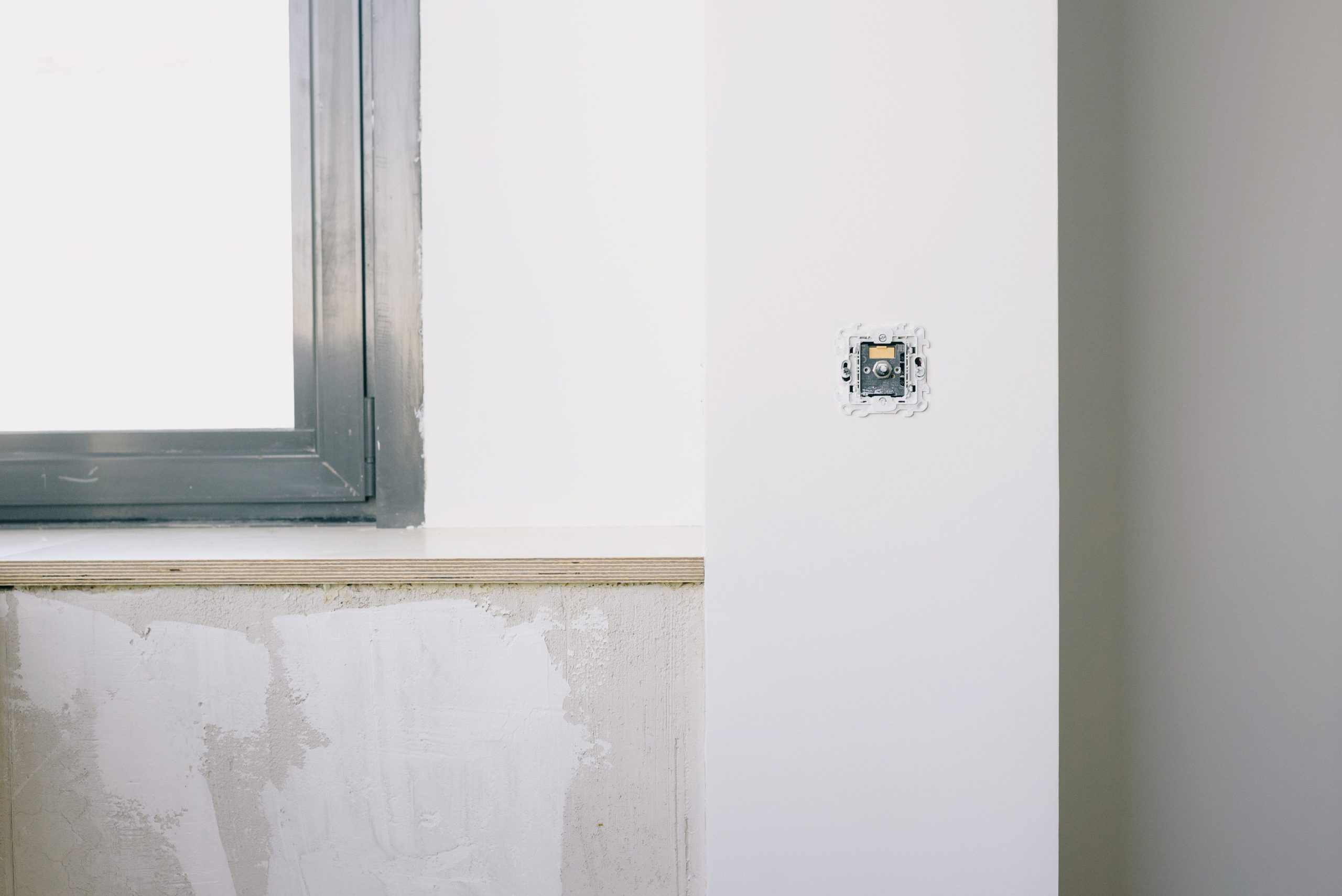 Réparation d'une prise électrique sur mur blanc
